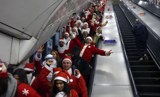 Participants in Santa costumes on an escalator at Brixton Underground station, as they make their way to take part in Santacon London 2018, in London, Saturday, December 8, 2018. (Photo by Gareth Fuller/PA Wire via AP Photo)