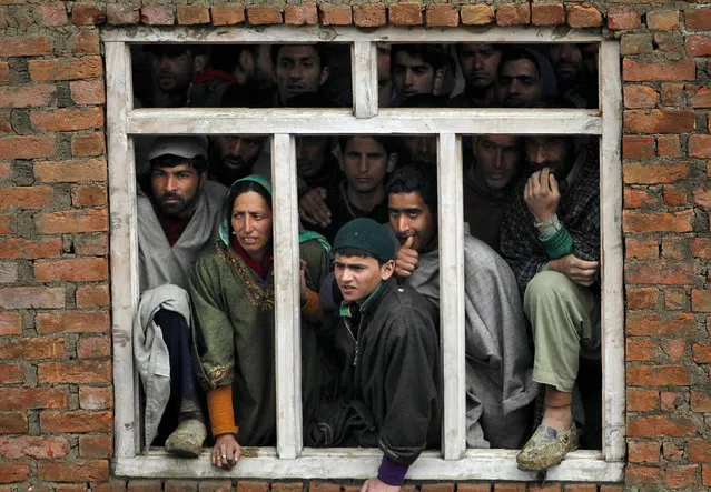 Villagers watch the rescue operation at the site of a damaged house after a hillside collapsed onto a house at Laden village, west of Srinagar, March 30, 2015. A hillside collapsed onto a house in Ledhan village, about 40 km (25 miles) from the capital Srinagar, where three families were sleeping on Monday morning, according to Mushtaq Ahmad, a neighbor. (Photo by Danish Ismail/Reuters)