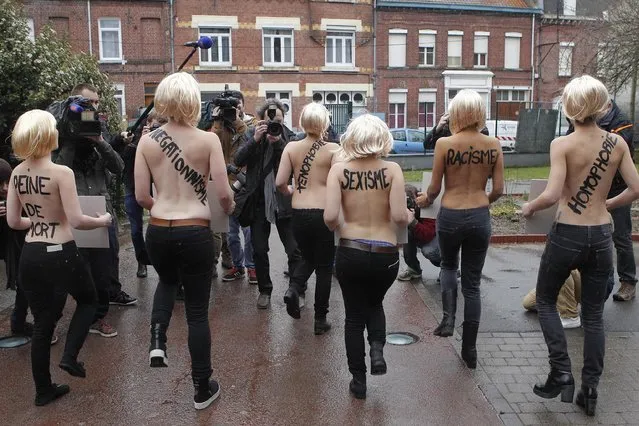A group of FEMEN activists, with the words “death sentence, revisionist, xenophobia, sexism, racism and homophobia”, painted on their backs, demonstrate where French far-right leader Marine Le Pen voted in the second round of local elections, Sunday, March 29, 2015, in Henin-Beaumont, northern France. French voters are choosing members of local councils in runoff elections Sunday seen as a test for the far right National Front, which is expanding its presence in French politics. (Photo by Michel Spingler/AP Photo)