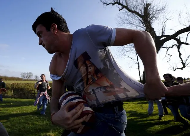 A player breaks with the bottle during the bottle-kicking game in Hallaton, central England April 6, 2015. (Photo by Darren Staples/Reuters)