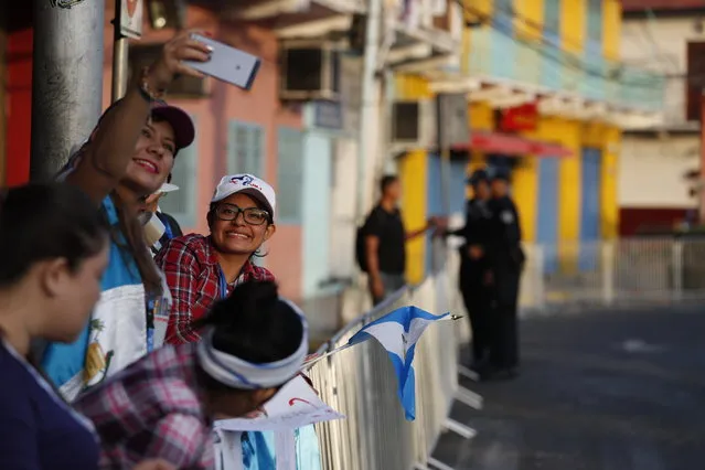 Guatemalan pilgrims pose for a photo behind a crowd barrier as they wait for Pope Francis to ride past on his way to the presidential palace, in Panama City, Thursday, January 24, 2019. Francis is in Panama to attend World Youth Day, the church's once-every-three-year pep rally that aims to invigorate the next generation of Catholics in their faith. (Photo by Rebecca Blackwell/AP Photo)