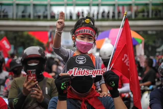 A child sits on the shoulders of an anti-government protester while making a three-finger salute on August 15, 2021 in Bangkok, Thailand. The latest round of protests came after a week of activity in which protesters clashed with police multiple times, despite Covid-19 cases remaining at record highs as frustration builds over Thailand's vaccine rollout. (Photo by Lauren DeCicca/Getty Images)