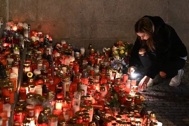Mourners bring flowers and candles outside the building of Philosophical Faculty of Charles University in downtown Prague, Czech Republic, Saturday, December 23, 2023. A lone gunman opened fire at a university on Thursday, killing more than a dozen people and injuring scores of people. (Photo by Denes Erdos/AP Photo)