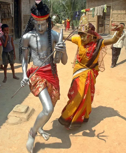 Artists dressed as Lord Shiva (L) and his wife Gauri perform in the street in Agartala March 31, 2007. (Photo by Jayanta Dey/Reuters)