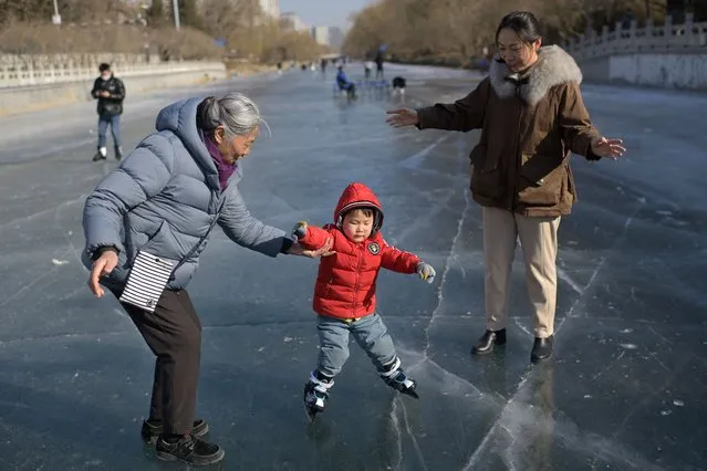 A child ice skates on a frozen river in Beijing on January 28, 2024. (Photo by Pedro Pardo/AFP Photo)