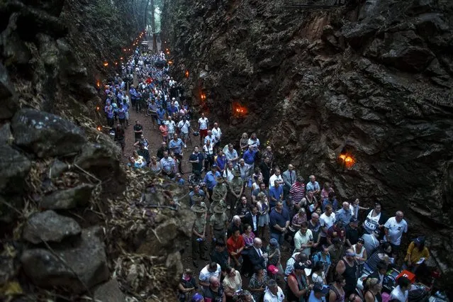 People gather at Hellfire Pass, a railway cutting on the Burma-Siam “Death Railway” constructed during the Japanese occupation, during a dawn memorial service for soldiers who died during World War Two on ANZAC Day at Hellfire Pass in Kanchanaburi province, Thailand, April 25, 2015. The dawn ceremony was held for the prisoners of war (POWs) who were forced to work and died on the Burma-Siam railway during the Japanese occupation. (Photo by Athit Perawongmetha/Reuters)