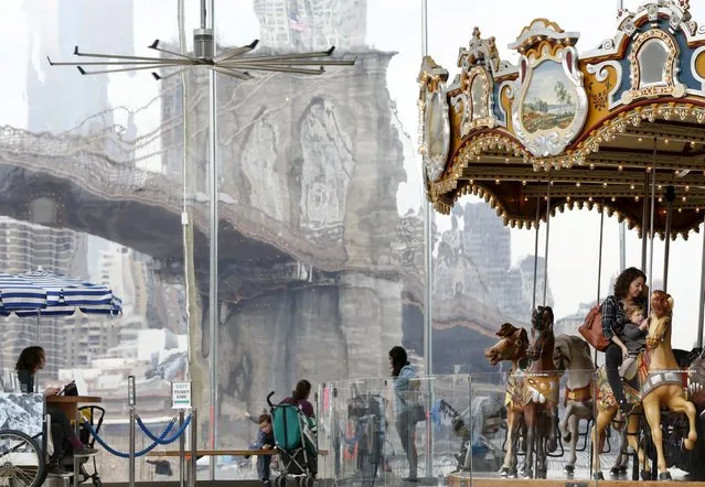A woman and child ride Jane's Carousel at the Brooklyn Bridge Park in New York March 10, 2016. (Photo by Shannon Stapleton/Reuters)