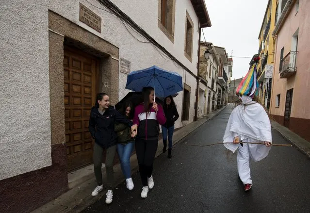 A reveller, dressed as a “Zarramache”, chases a group of young girls during celebrations to mark Saint Blaise festivity in Casavieja, Spain February 3, 2017. (Photo by Sergio Perez/Reuters)