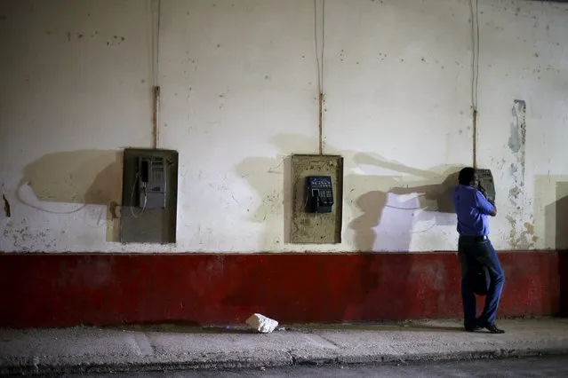 A man uses a public phone in a street at Havana city, Cuba, March 17, 2016. (Photo by Ivan Alvarado/Reuters)