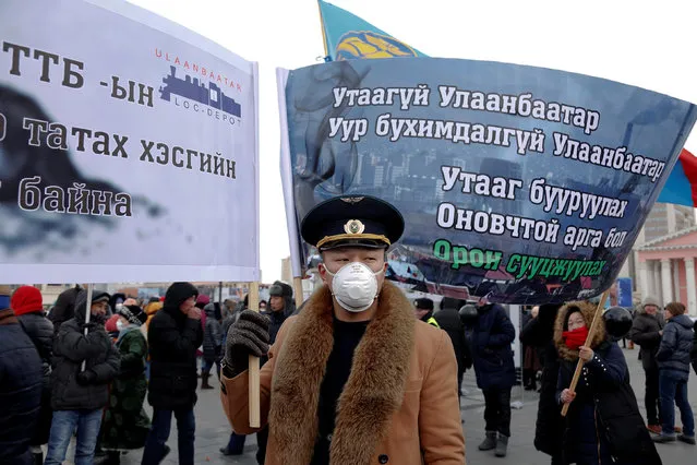 A protester wears a face mask and holds a banner during an anti-pollution protest in central Ulaanbaatar, Mongolia January 28, 2017. The banners read: “Smoke-free Ulaanbaatar”, “No More Agony for Ulaanbaatar”, “The Solution to Reducing Air Pollution is Urban Development”. (Photo by B. Rentsendorj/Reuters)