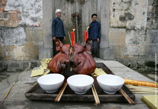 A pig head used as an offering to worship ancestors is displayed before Tujia ethnic minority people perform the Waving Hands dancing at Houxi Township