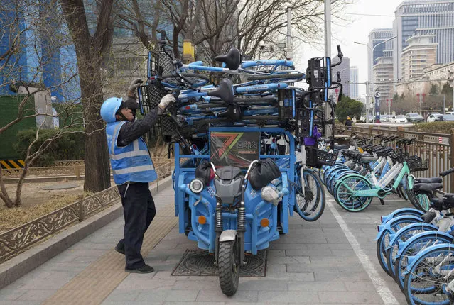 A worker unloads bicycles from a bike-share service in Beijing, China, Thursday, March 21, 2024. (Photo by Tatan Syuflana/AP Photo)