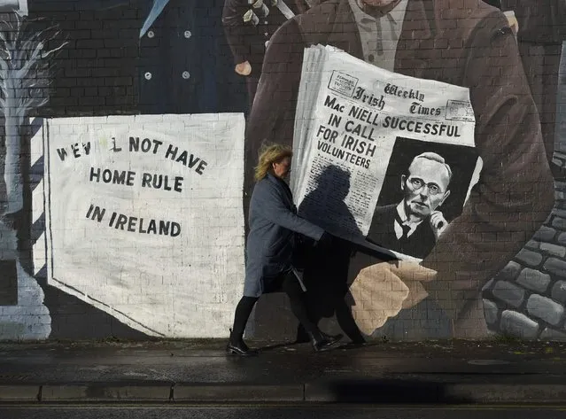 A woman walks past a mural on the Falls Road a day after Northern Ireland's Deputy First Minister Martin McGuinness resigned, throwing the devolved joint administration into crisis, in Belfast Northern Ireland, January 10, 2017. (Photo by Clodagh Kilcoyne/Reuters)