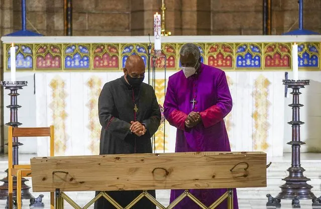 The Dean of St George's Cathedral Michael Weeder (L) and Archbishop of Cape Town Thabo Makgoba (R) stand near the coffin of late Archbishop Emeritus Desmond Tutu in St. George's Cathedral in Cape Town, South Africa, 30 December 2021. The anti-apartheid leader and Nobel Peace Prize laureate, who was a key figure in the dismantling of apartheid, died on 26 December 2021 at the age of 90. His body will lie in repose at St George's Cathedral until his full state funeral on 01 January 2022. (Photo by Nic Bothma/EPA/EFE)