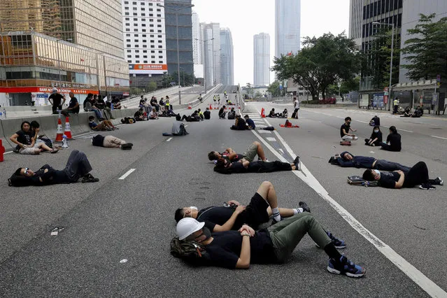 Protesters who camped out overnight take a rest along a main road near the Legislative Council after continuing protest against the unpopular extradition bill in Hong Kong, Monday, June 17, 2019. Hong Kong police and protesters faced off Monday as authorities began trying to clear the streets of a few hundred who remained near the city government headquarters after massive demonstrations that stretched deep into the night before. (Photo by Vincent Yu/AP Photo)