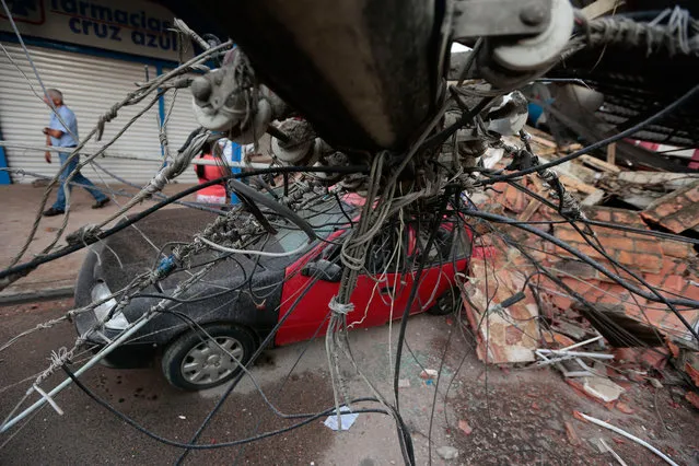 View of a car squashed by rubble after a 7.8-magnitude quake in Portoviejo, Ecuador on April 17, 2016. (Photo by Juan Cevallos/AFP Photo)