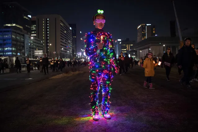 An anti- government protester wearing an illuminated costume takes part in a rally in Seoul on March 4, 2017. Tens of thousands of South Korean protesters held rival mass rallies over the impeachment of President Park Geun- Hye as judges prepare to rule on the scandal that has rocked the country. (Photo by Ed Jones/AFP Photo)