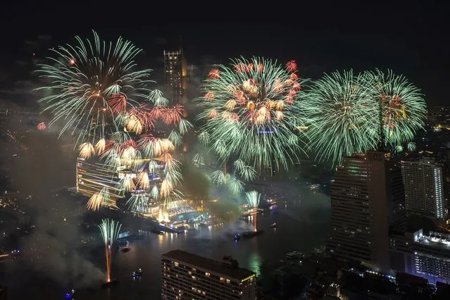 Fireworks explode over the Chao Phraya River during New Year celebrations in Bangkok, Thailand, Saturday, January 1, 2022. (Photo by Wason Wanichakorn/AP Photo)