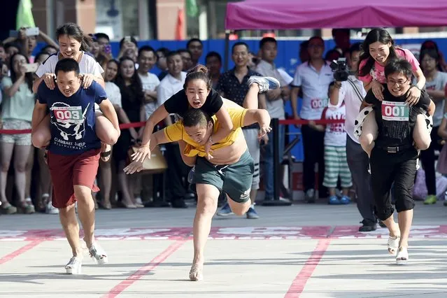 A couple fall as they take part in a high-heels race in Taiyuan, Shanxi province, China, July 3, 2015. The winning couple won a diamond ring after the 50 meter race, according to local media. (Photo by Reuters/Stringer)