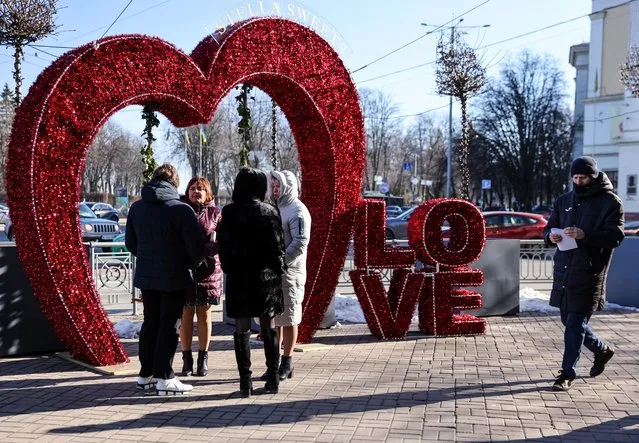 Women chat beside a heart-shaped decoration during Valentine's Day in Kyiv, Ukraine, February 14, 2022. (Photo by Umit Bektas/Reuters)