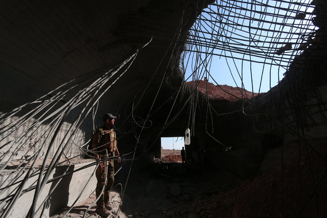 A Syrian Democratic Forces (SDF) fighter inspects a damaged building inside Tabqa military airport after taking control of it from Islamic State fighters, west of Raqqa city, Syria April 9, 2017. (Photo by Rodi Said/Reuters)