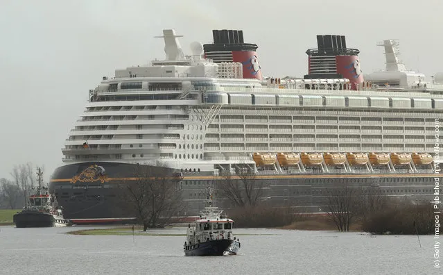 Tugboats haul the “Disney Fantasy” cruise ship backwards down Ems river after the ship departed from the Meyer Werft shipyards