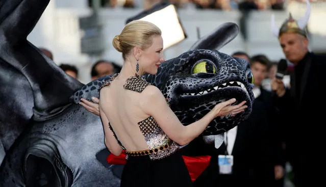 Actress Cate Blanchett touches a giant puppet of the dragon named Toothless during arrivals for the screening of How to Train Your Dragon 2 at the 67th international film festival, Cannes, southern France, Friday, May 16, 2014. (Photo by Alastair Grant/AP Photo)