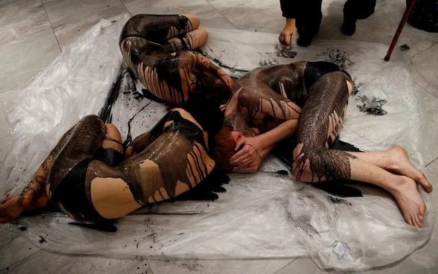 Extinction Rebellion members lie on the ground, covered in fake crude oil, to protest an exhibition sponsored by BP at The National Portrait Gallery in London, Britain October 20, 2019. (Photo by Henry Nicholls/Reuters)