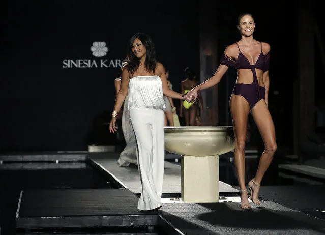 Designer Sinesia Karol, left, walks on the runway with a model during the Sinesia Karol swimwear show as part of Funkshion Fashion Week Swim, Friday, July 17, 2015, in Miami Beach, Fla. (Photo by Lynne Sladky/AP Photo)