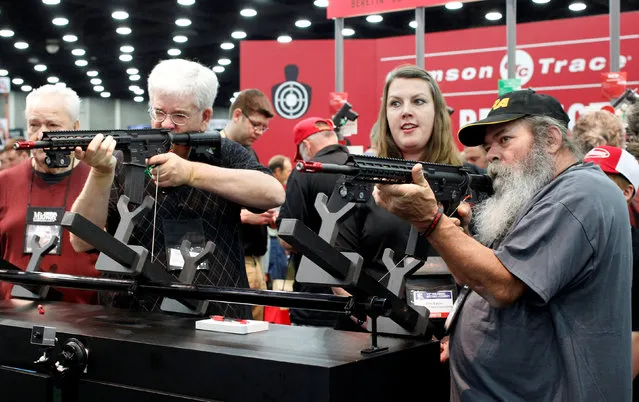 Gun enthusiasts test out laser sights at Crimson Trace Corp. at the National Rifle Association's annual meetings and exhibits show in Louisville, Kentucky, May 21, 2016. (Photo by John Sommers II/Reuters)