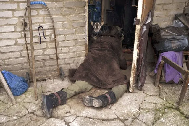 A dog stands next to the body of an elderly woman killed at the entrance of her house in Bucha, outskirts of Kyiv, Ukraine, Tuesday, April 5, 2022. (Photo by Felipe Dana/AP Photo)