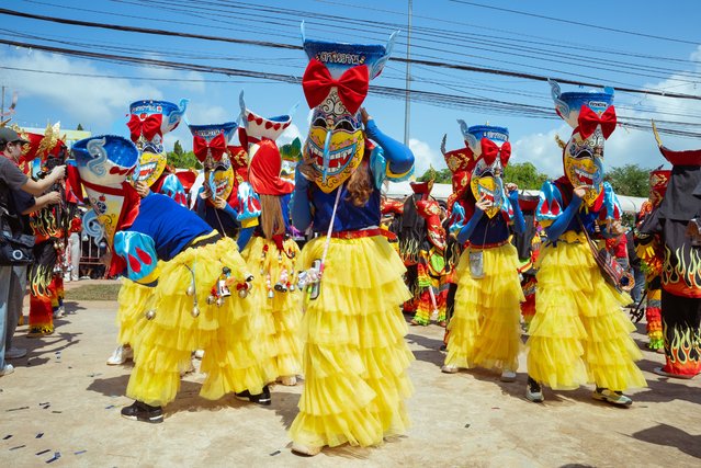 A group of dancers wearing costumes similar to that of Disney's Snow White dance in Dan Sai on July 09, 2024 in Loei, Thailand. The Phi Ta Khon Festival in Dan Sai, Loei province is a vibrant three-day celebration featuring colorful masked processions, raucous parties, and traditional ghost masks made from dried palm leaves and bamboo sticky rice baskets. Locals dress up in elaborate costumes with exaggerated features, some carrying wooden phalluses as symbols of fertility, while others daub their bodies in mud to represent rice fields. The festival combines elements of Buddhist merit-making, animistic beliefs, and Brahmanistic traditions as the townspeople invite protection from spirits and pray for bountiful rains for the coming farming season. (Photo by Mailee Osten-Tan/Getty Images)