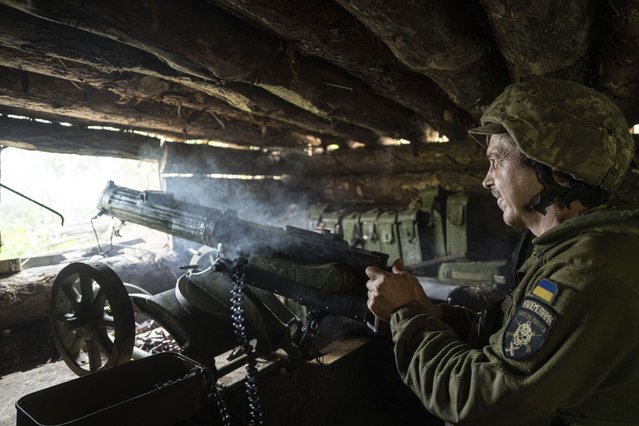 A Ukrainian serviceman of 28th brigade shoots a Maxim gun towards Russian positions at the frontline in Donetsk region, Ukraine, Wednesday, June 21, 2023. (Photo by Evgeniy Maloletka/AP Photo)