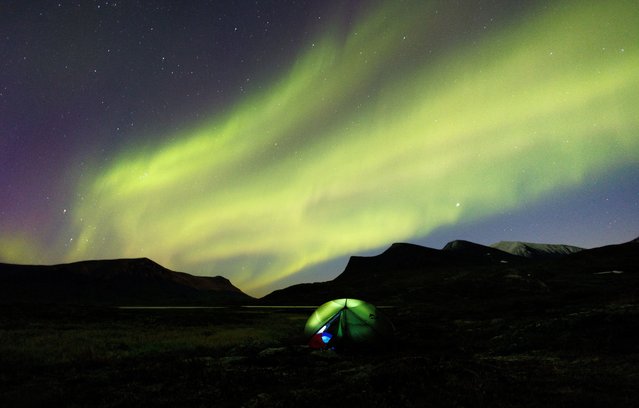 The Aurora Borealis in the night sky over a camping tent in Lapland, near Abisko, Sweden, on September 8, 2022. (Photo by Lisi Niesner/Reuters)