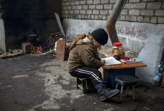 A child draws near her house in Debaltseve, eastern Ukraine, February 5, 2015. Five more Ukrainian soldiers have been killed in fighting with Russian-backed separatists in the past 24 hours, a military spokesman said on Thursday. The fresh casualties were announced as separatists continued attacks on Debaltseve, a key rail hub northeast of the big city of Donetsk which government troops are holding despite strong pressure from the rebels. (Photo by Gleb Garanich/Reuters)