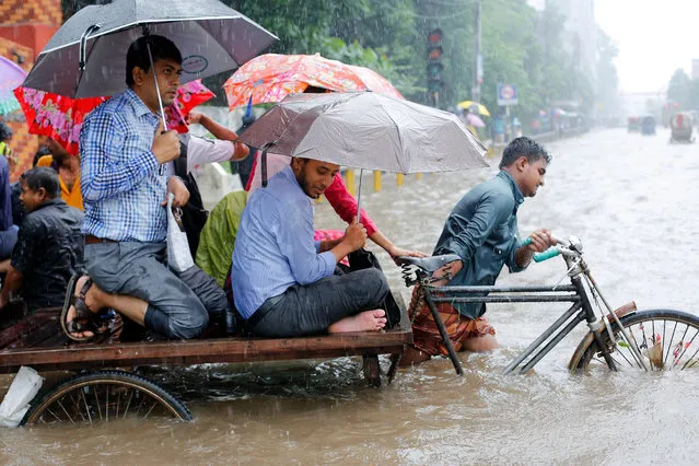 A driver carries passengers through flooded streets during a heavy downpour in Dhaka, Bangladesh, 26 July 2017. Heavy rains caused floods in the streets making travel difficult. (Photo by Abir Abdullah/EPA)