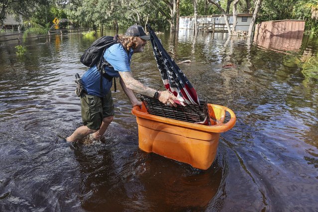 A man who identified himself as Jesse walks out through floodwaters of the Anclote River after Hurricane Milton hit the region, Thursday, October 10, 2024, in New Port Richey, Fla. (Photo by Mike Carlson/AP Photo)