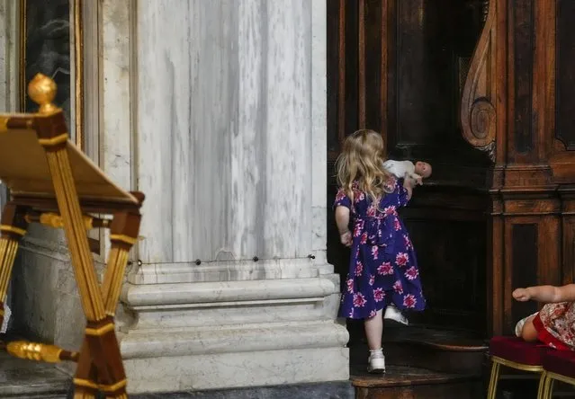A child picks up her doll from confession booth inside the St. Mary Major Basilica, in Rome, Tuesday, May 31, 2022. (Photo by Gregorio Borgia/AP Photo)