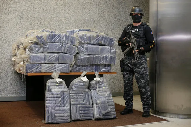 A Romanian special forces unit member stands guard near bags containing part of 2.5 tonnes of cocaine seized in the Black Sea port of Constanta, Romania, July 1, 2016. (Photo by Octav Ganea/Reuters/Inquam Photos)