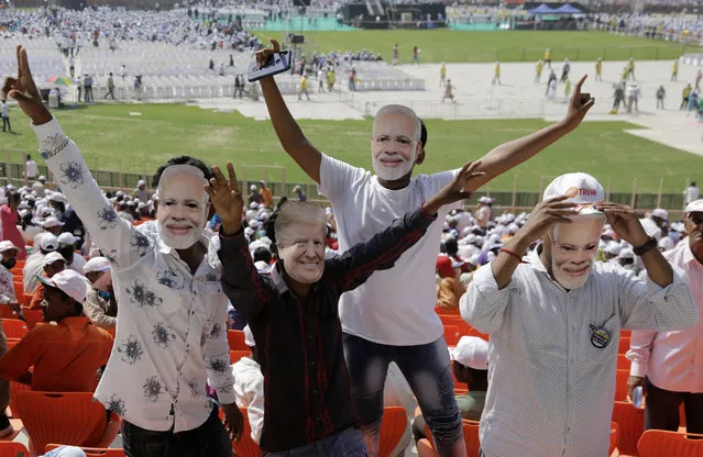 Indians wear masks of U.S. President Donald Trump and Indian Prime Minister Narendra Modi and cheer as they attend the Namaste Trump event at Sardar Patel Stadium in Ahmedabad, India, Monday, February 24, 2020. Hundreds of thousands of people in the northwestern city are expected to greet Trump on Monday for a road show leading to a massive rally at what has been touted as the world's largest cricket stadium. (Photo by Ajit Solanki/AP Photo)