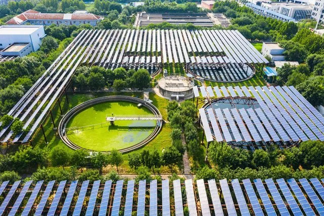 This aerial photo taken on August 4, 2022 shows solar panels built over a sewage treatment plant, as the plant uses photovoltaic power to partly replace coal power, in Zhengzhou, in China's central Henan province. (Photo by AFP Photo/China Stringer Network)