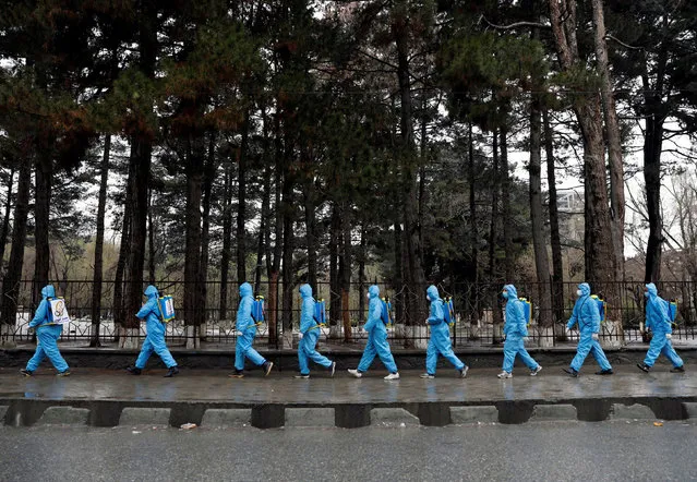 Volunteers prepare themselves to spray disinfectants on streets and shops amid concerns about coronavirus disease (COVID-19) in Kabul, Afghanistan on March 30, 2020. (Photo by Mohammad Ismail/Reuters)
