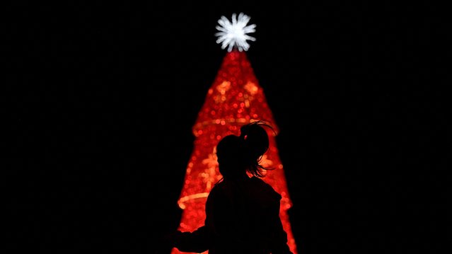 A woman jumps ropes in front of a Christmas tree, as the Christmas season kicks off as per a decree of Venezuela's President Nicolas Maduro, in Caracas, Venezuela on October 1, 2024. (Photo by Gaby Oraa/Reuters)