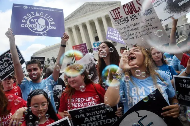 Anti-abortion campaigners celebrate outside the US Supreme Court in Washington, DC, on June 24, 2022. The US Supreme Court on Friday ended the right to abortion in a seismic ruling that shreds half a century of constitutional protections on one of the most divisive and bitterly fought issues in American political life. The conservative-dominated court overturned the landmark 1973 “Roe v Wade” decision that enshrined a woman's right to an abortion and said individual states can permit or restrict the procedure themselves. (Photo by Olivier Douliery/AFP Photo)