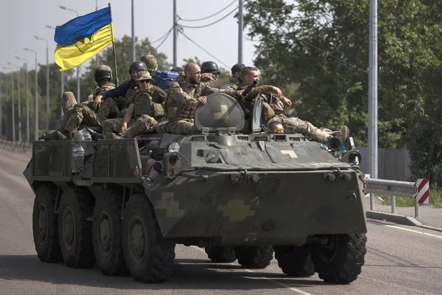 Ukrainian servicemen ride atop of an armored vehicle on a road in Donetsk region, eastern Ukraine, Sunday, August 28, 2022. (Photo by Leo Correa/AP Photo)