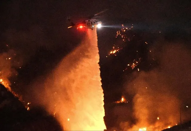 A Los Angeles County Fire Department helicopter makes a water drop at night during the so-called Sand Fire in the Angeles National Forest near Los Angeles, California, U.S. July 24, 2016. (Photo by Gene Blevins/Reuters)