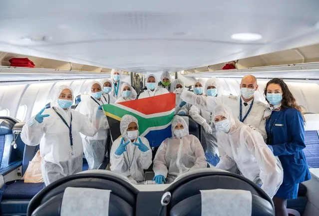 The crew of the Airbus A340-600 of the airline “South African Airlines” met after landing from Cape Town in their protective clothing on board for a photo in Hessen, Frankfurt am Main on April 24, 2020. It was the last return flight of the German government for the time being. (Photo by Silas Stein/picture alliance via Getty Images)