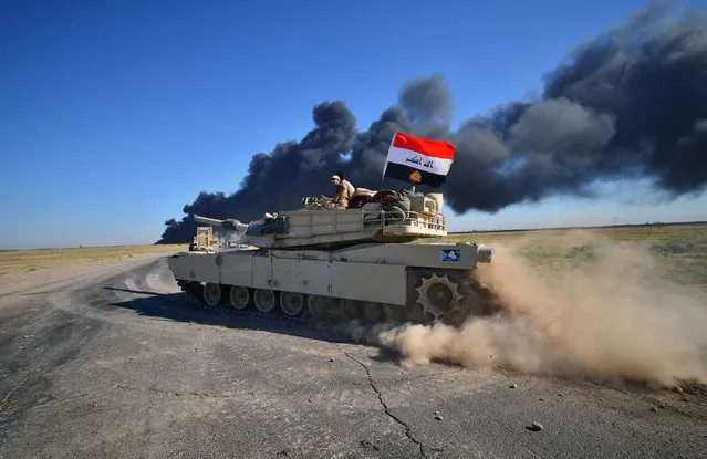 Iraqi army members ride on a tank on the outskirts of Hawija, Iraq October 4, 2017. (Photo by Reuters/Stringer)