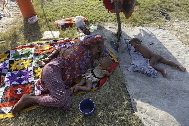 A woman sleeps on the ground as she takes refuge from her flood-hit home, in Larkana District, of Sindh, Pakistan, Thursday, September 8, 2022. (Photo by Fareed Khan/AP Photo)