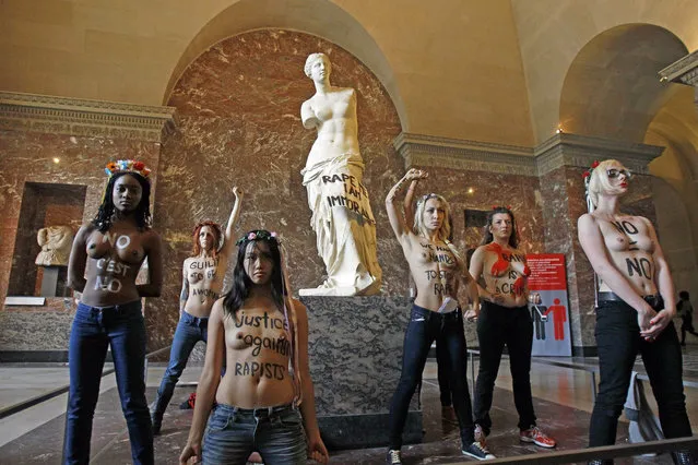 Topless Femen human rights activists stage a demonstration in front of the Venus of Milo statue, at the Louvre Museum in Paris, Wednesday Oct. 3, 2012. The women were protesting in support of a woman who was allegedly  raped by police in Tunisia and is facing accusations of violating modesty laws. (AP Photo/Remy de la Mauviniere)